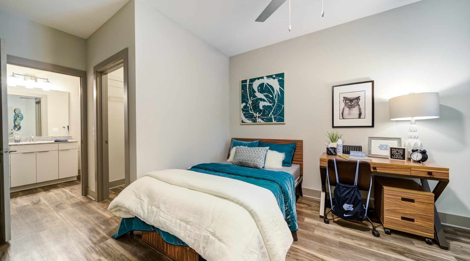 a bedroom with a bed desk and a chair