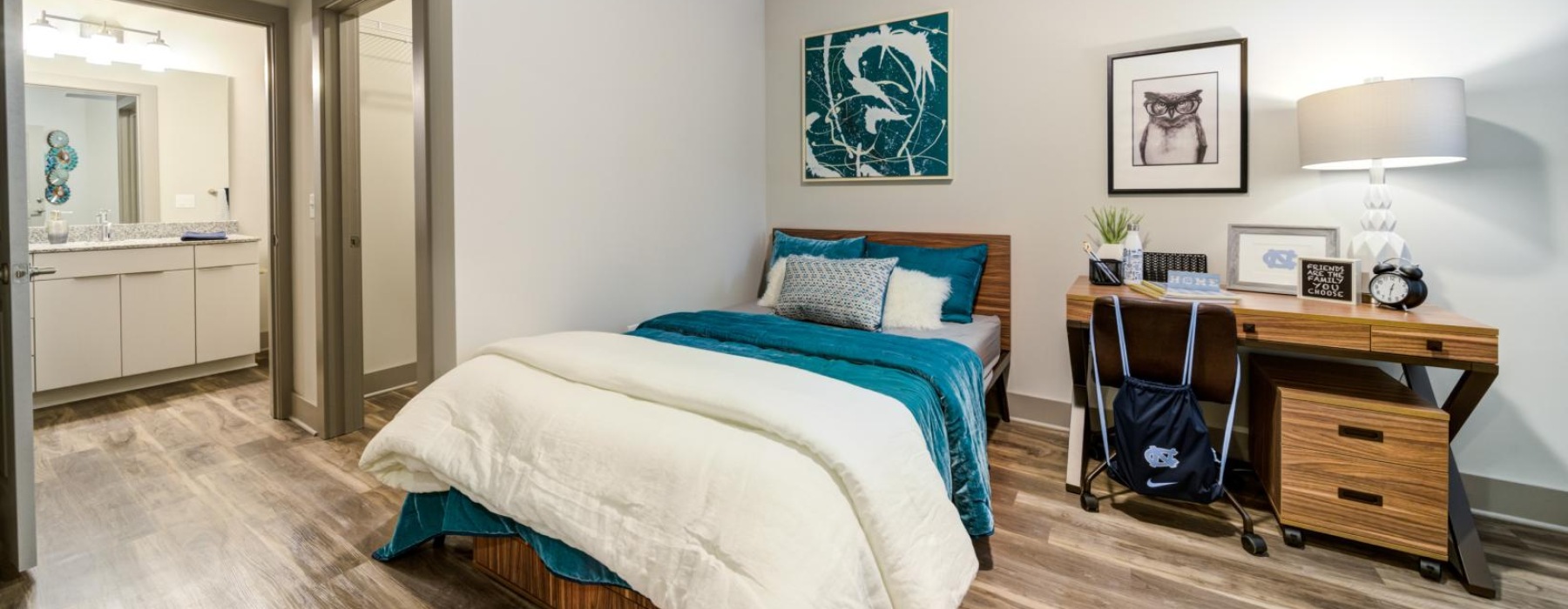 a bedroom with a bed desk and a chair