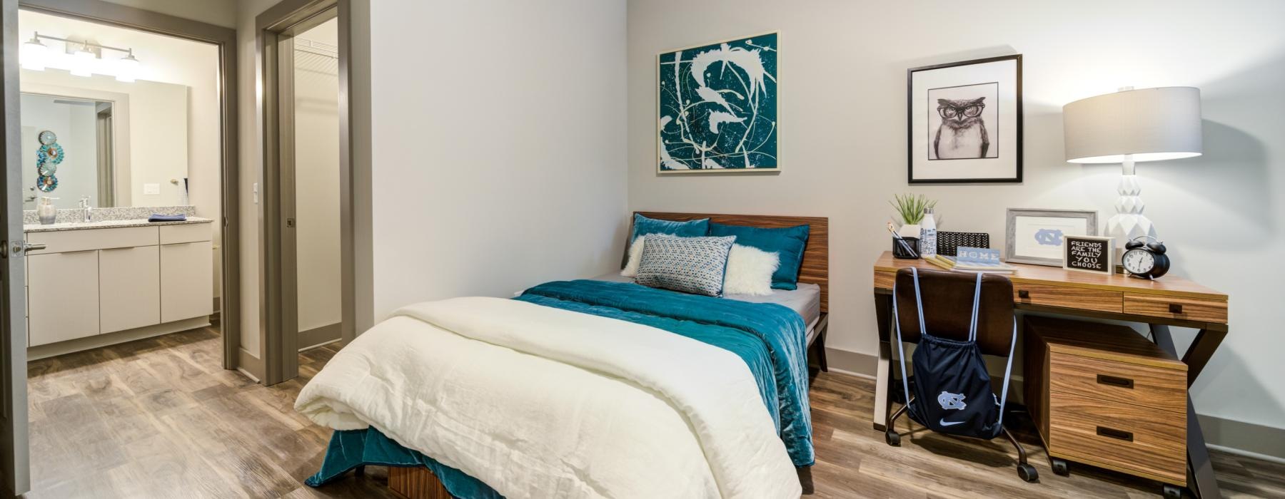 a bedroom with a bed desk and a chair