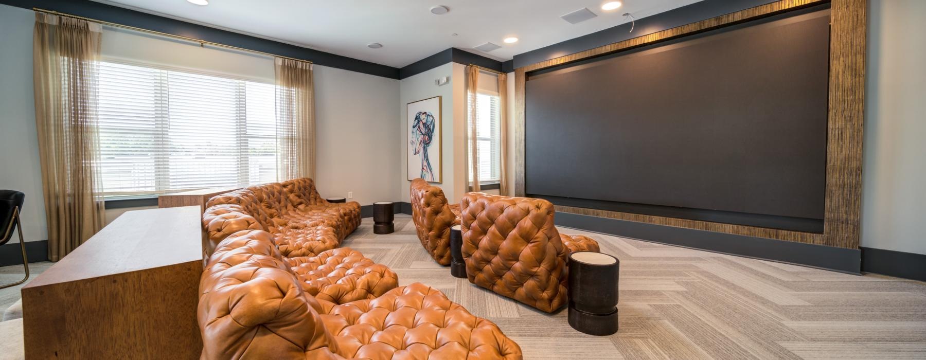 a room with a large screen and chairs